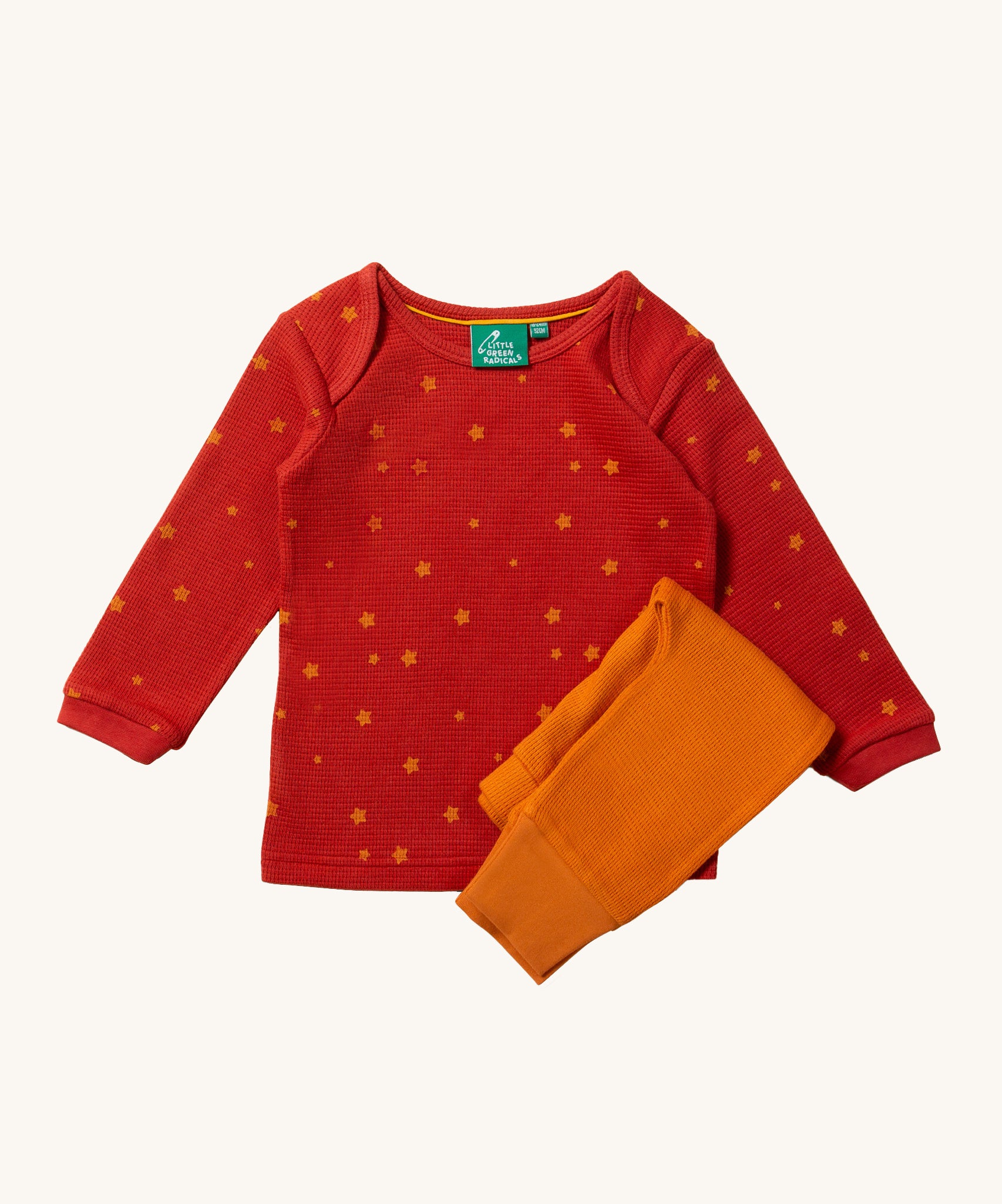 Little Green Radicals Waffle T-Shirt & Jogger Playset - Hazelnut Stars. A red long-sleeved top with little stars printed all over, and a pair of coordinating golden yellow joggers