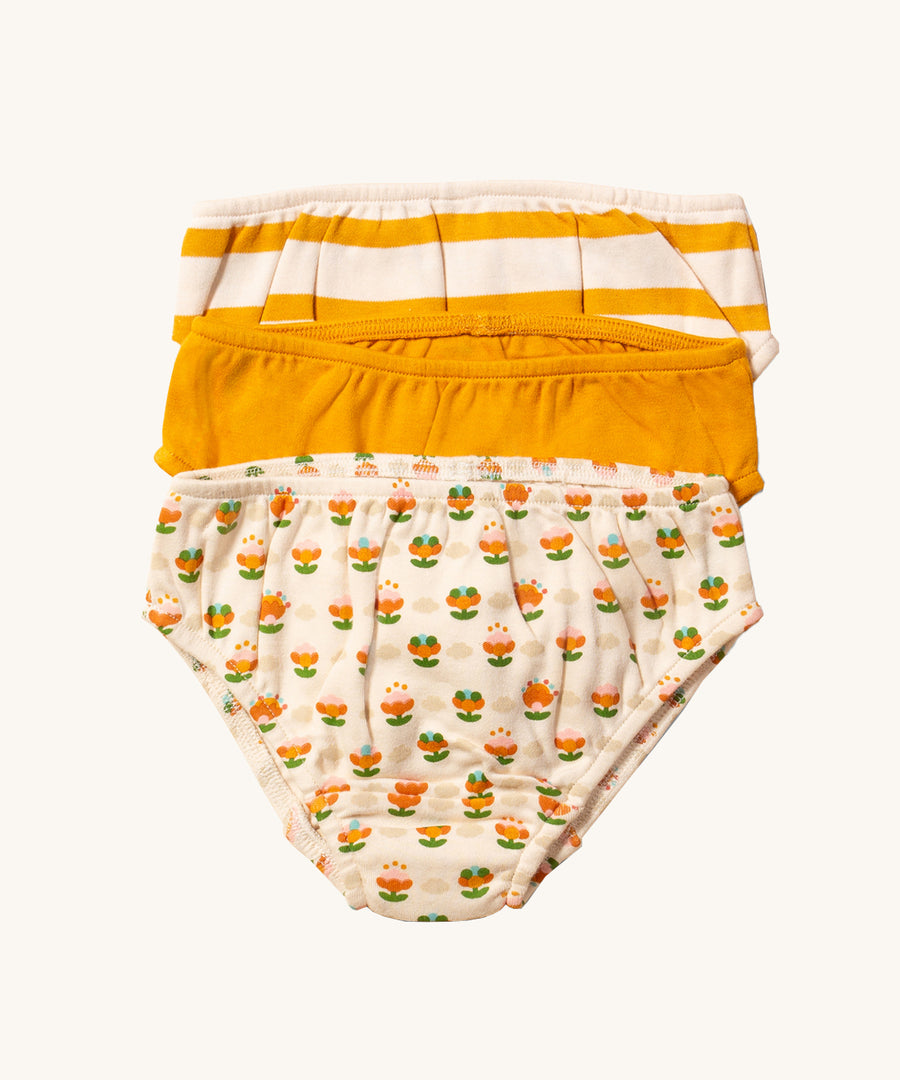 Little Green Radicals Cotton Underwear Set - Little Blooms. One pair of underwear is in a golden colourblock, one in a gold and cream stripe, and one in cream with a floral print