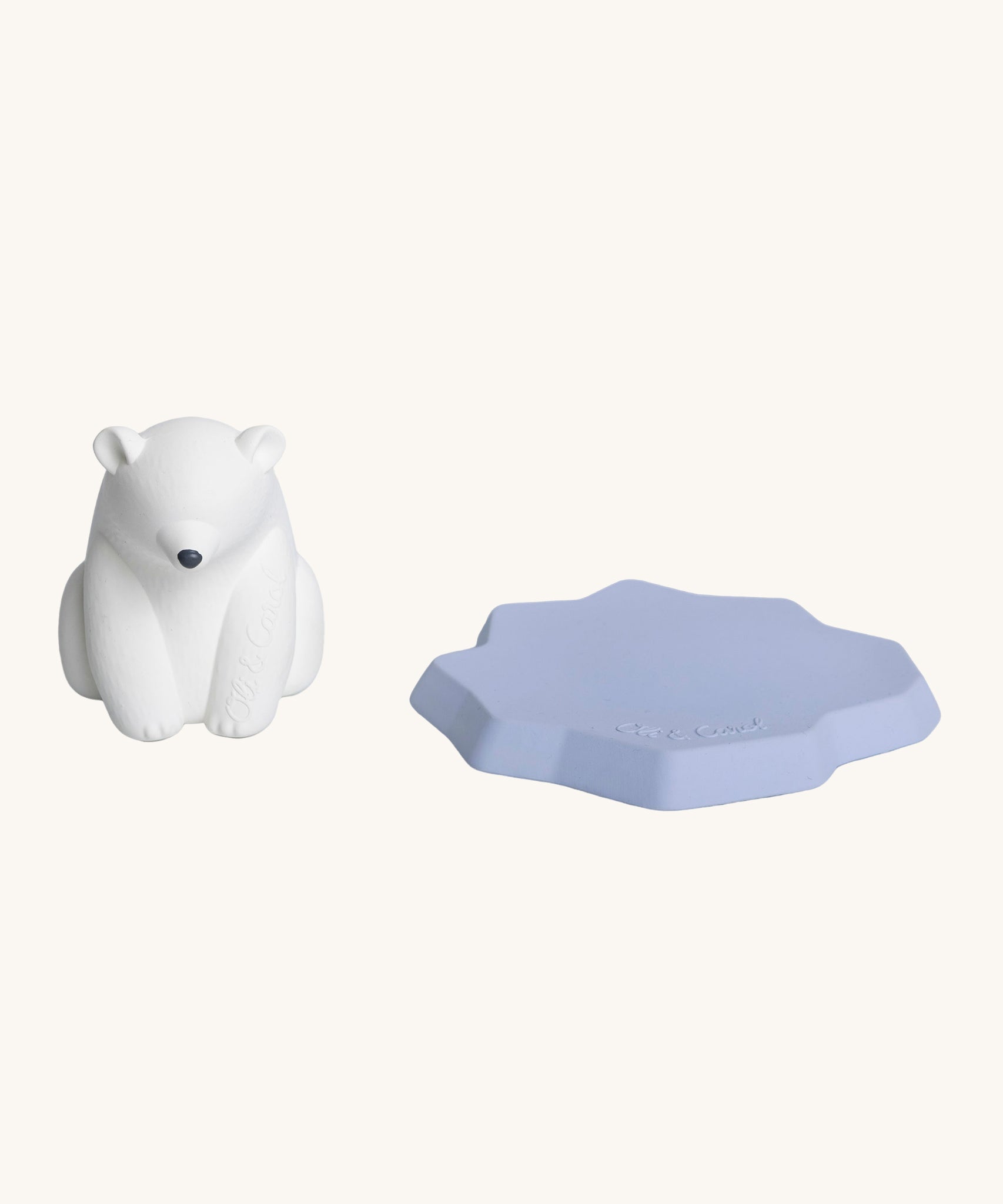 The Oli & Carol Polar Bear Bath Toy is stood next to its floating iceberg part to the right hand side. The image is on a cream background