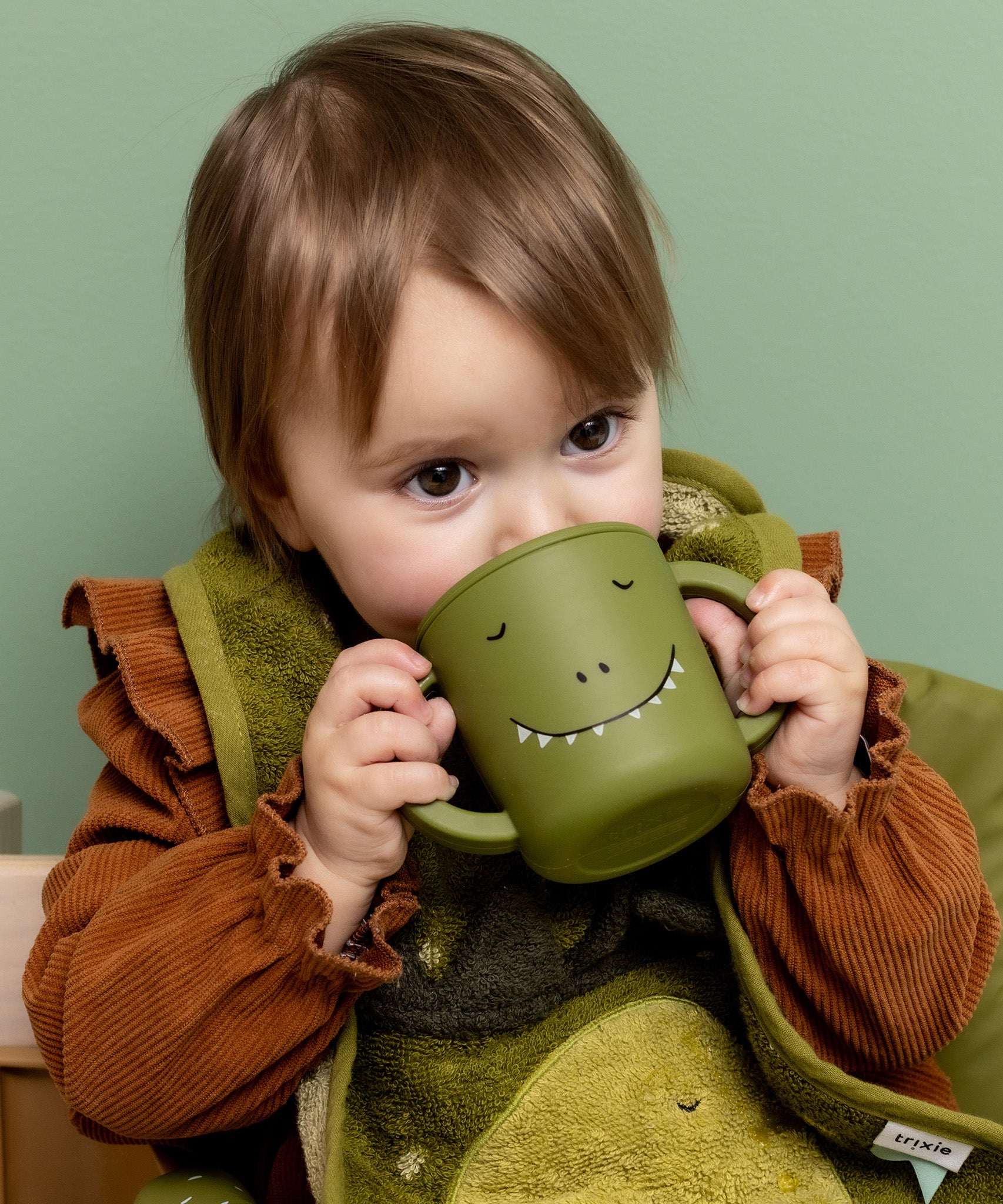 Baby drinking from the Trixie Animal Friends Silicone Sippy Cup, green, Mr Dino.