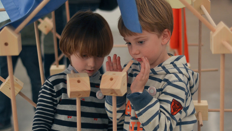 Two kids building with Trigonos wooden STEM toys