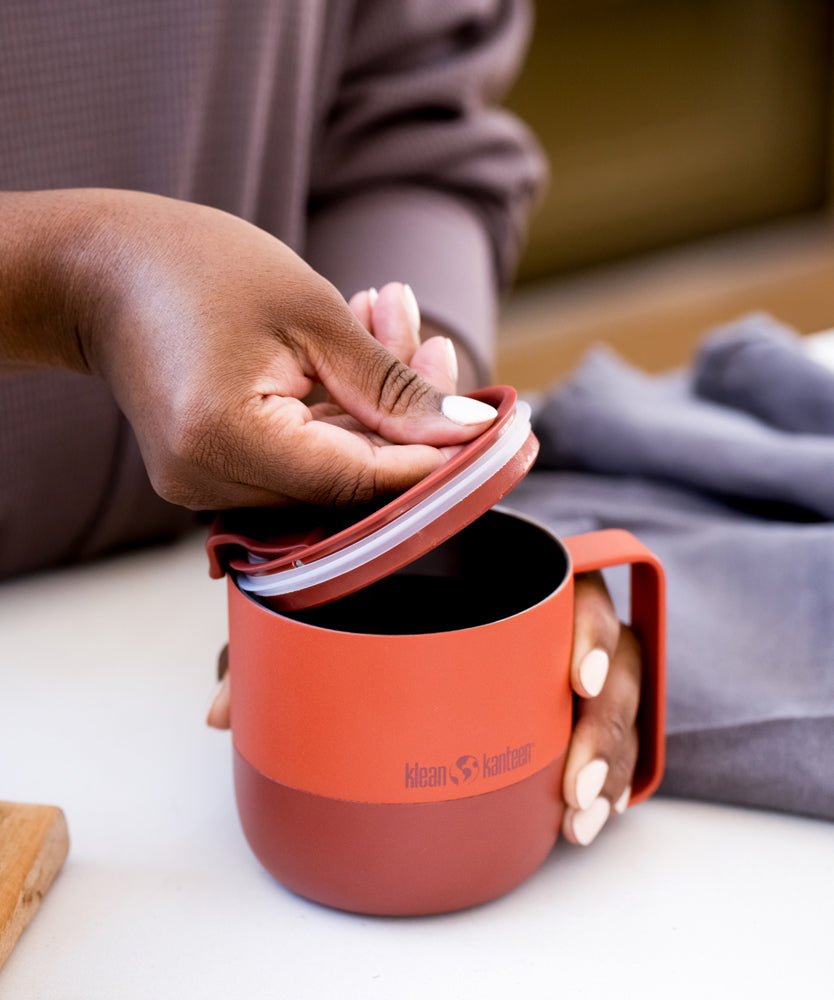 A person taking off the Klean Kanteen Rise Flip Lid off A Rise Tumbler Mug