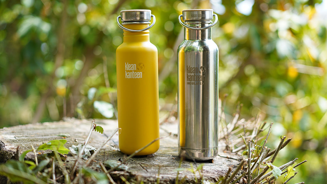 Two Klean Kanteen water bottles with a woodland background