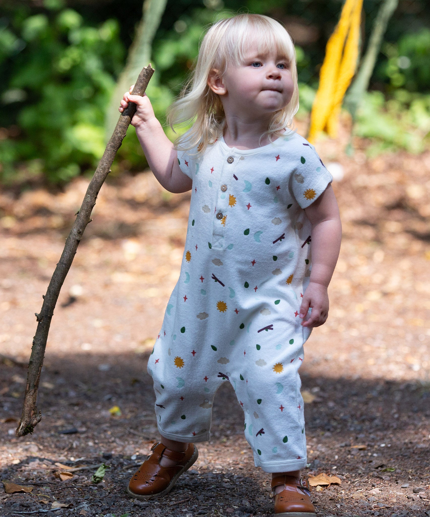 A child happily playing outside, wearing the LGR Adventure Baby Towelling Romper