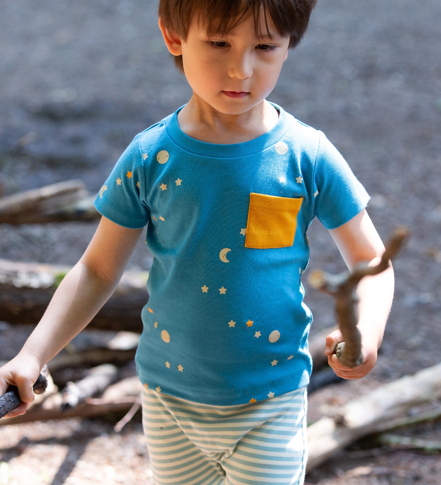 A child outside playing and wearing the LGR Dawn Organic T-Shirt & Jogger Playset