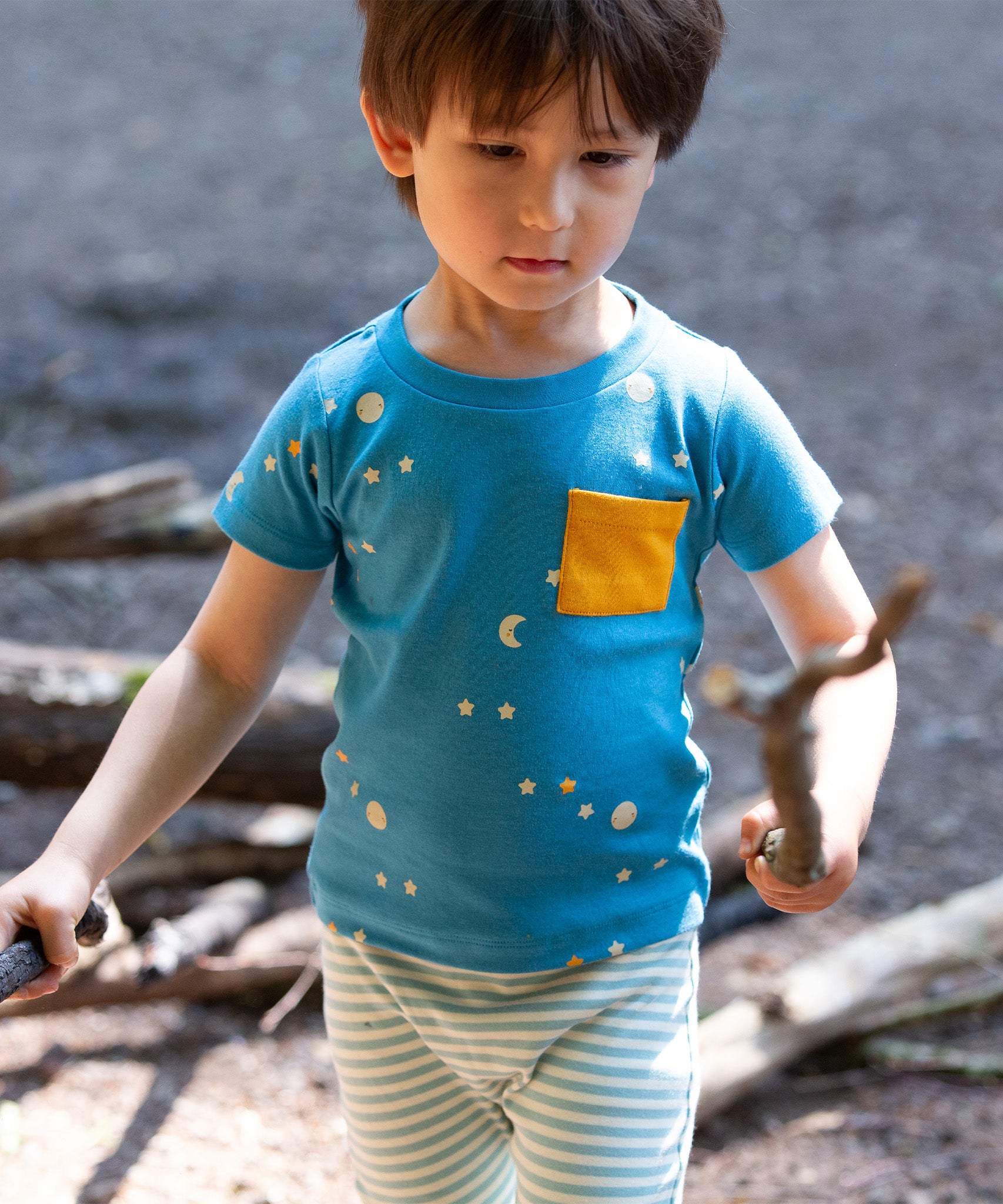 A child outside playing and wearing the LGR Dawn Organic T-Shirt & Jogger Playset