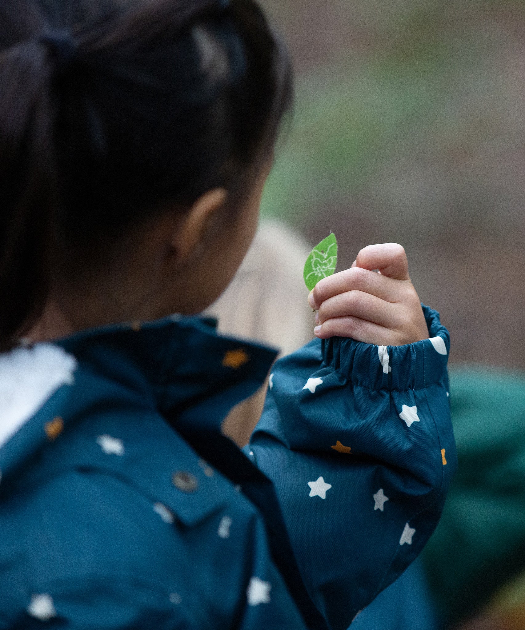 A closer look at the elasticated wrist cuffs on the LGR Adventure Waterproof Winter Coat, with an image of a child's hand holding a green leaf