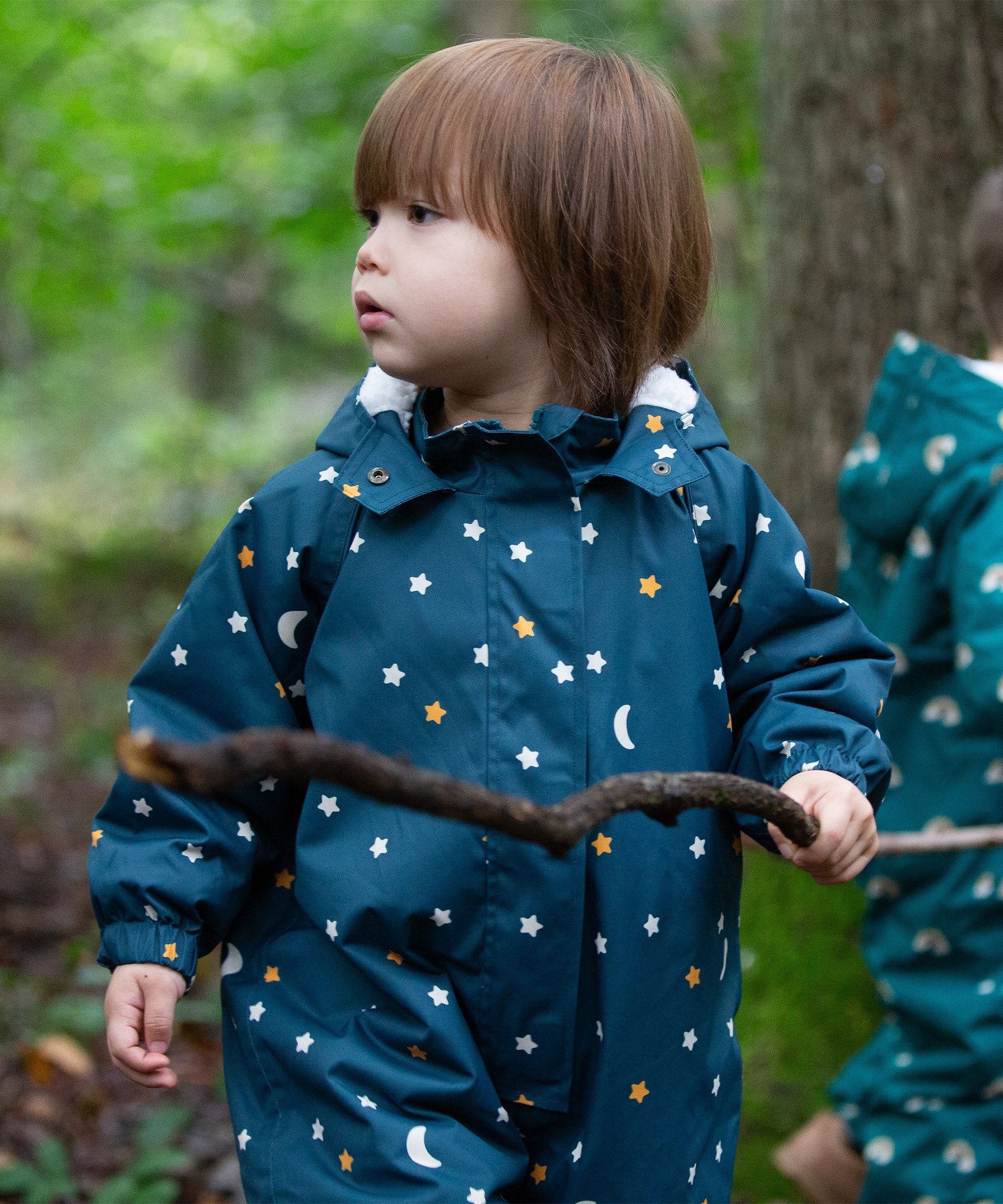 A child outside, wearing the LGR Starry Night Waterproof Winter Suit