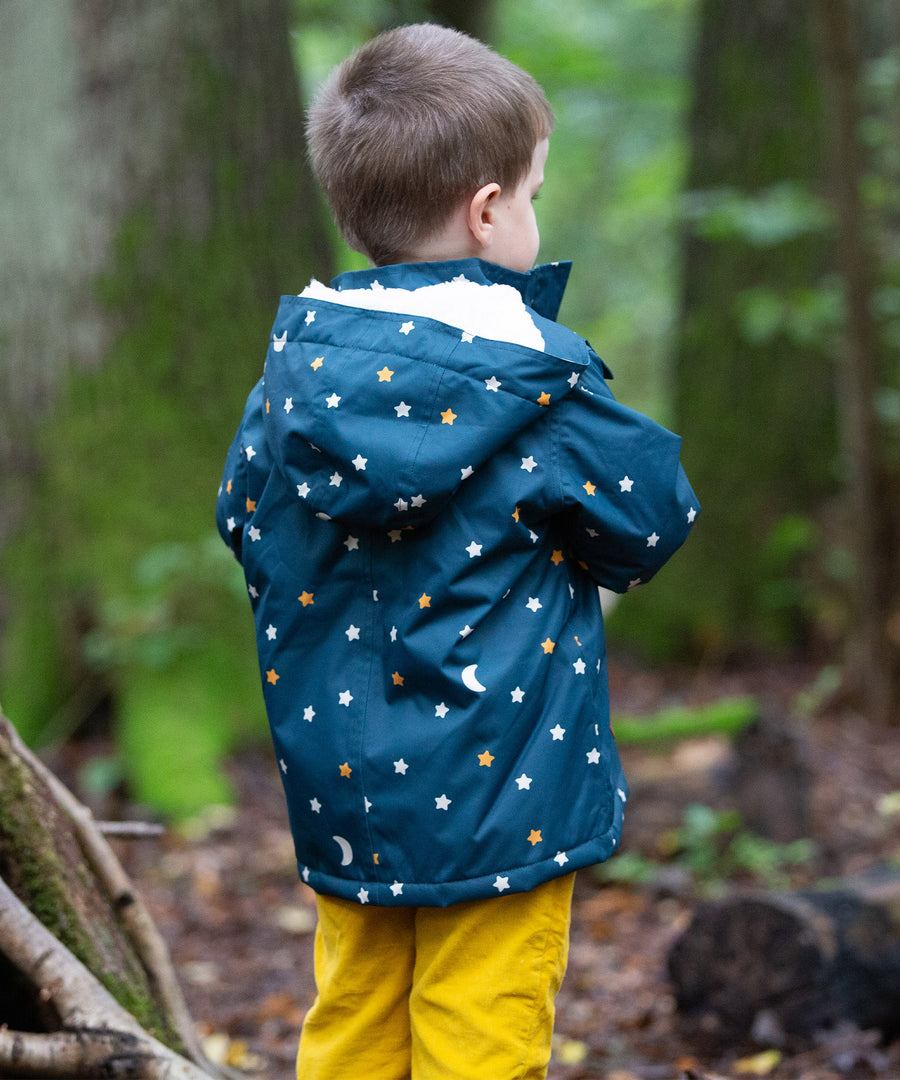 A child stood in a forest, wearing the LGR Adventure Waterproof Winter Coat