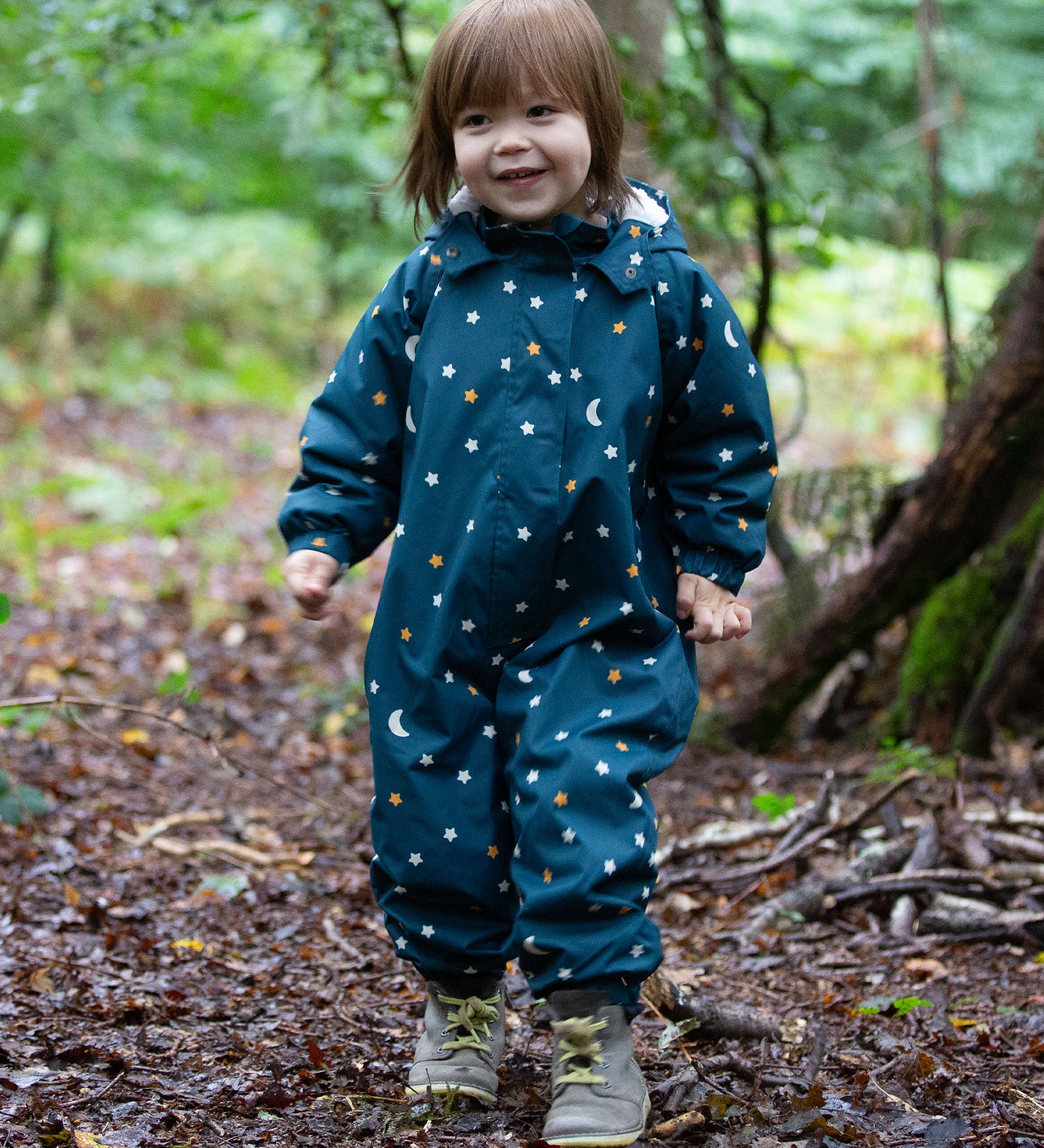 A child playing in the forest, wearing the LGR Starry Night Waterproof Winter Suit