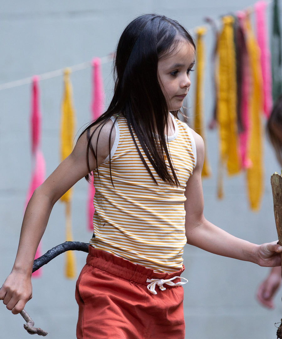 A child wearing the yellow stripe vest top, from the LGR Adventure Organic Vest Set - 3 Pack