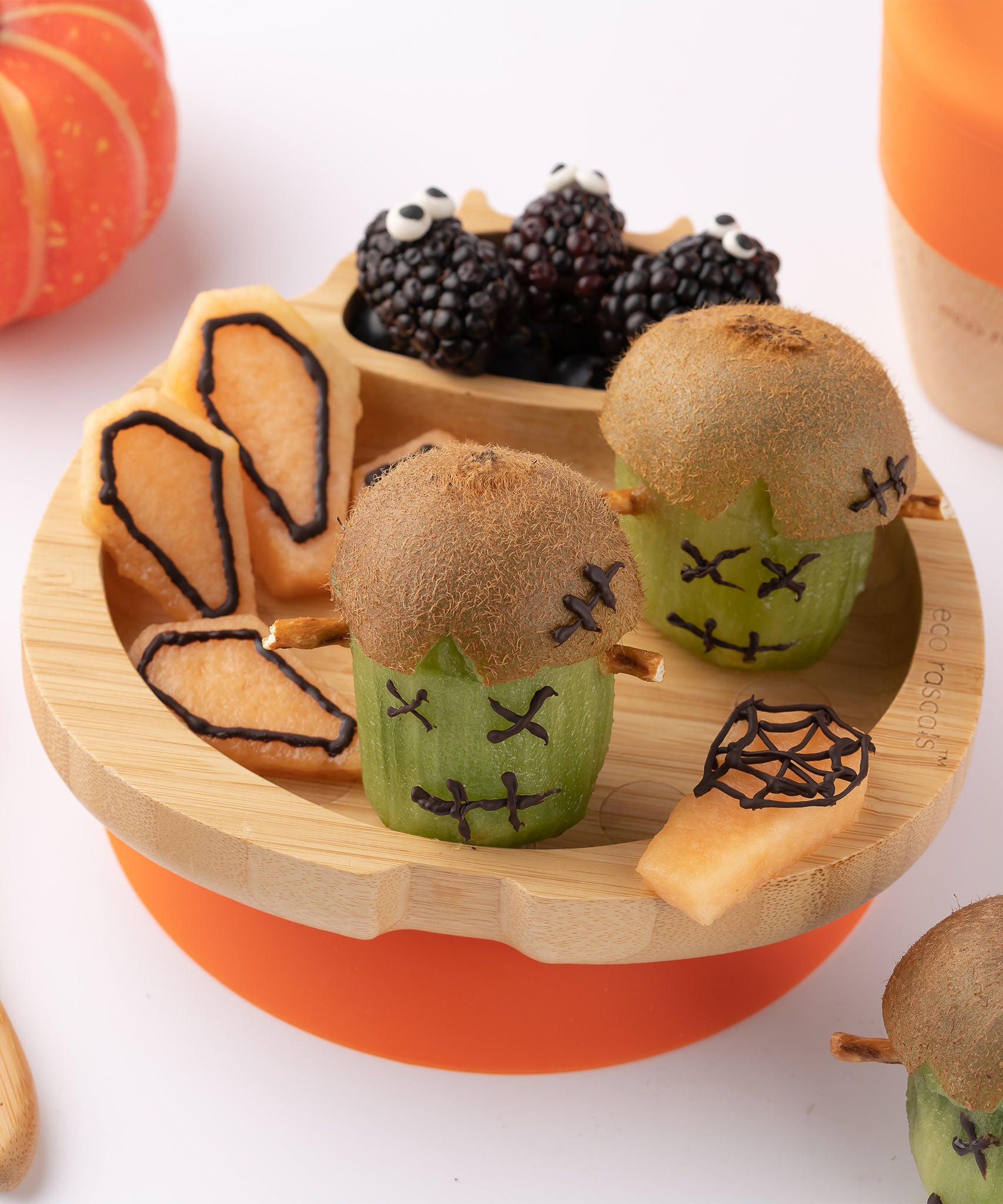 Eco Rascals Ladybird Bamboo Suction Plate with an orange silicone base filled with halloween decorated fruit treats. 