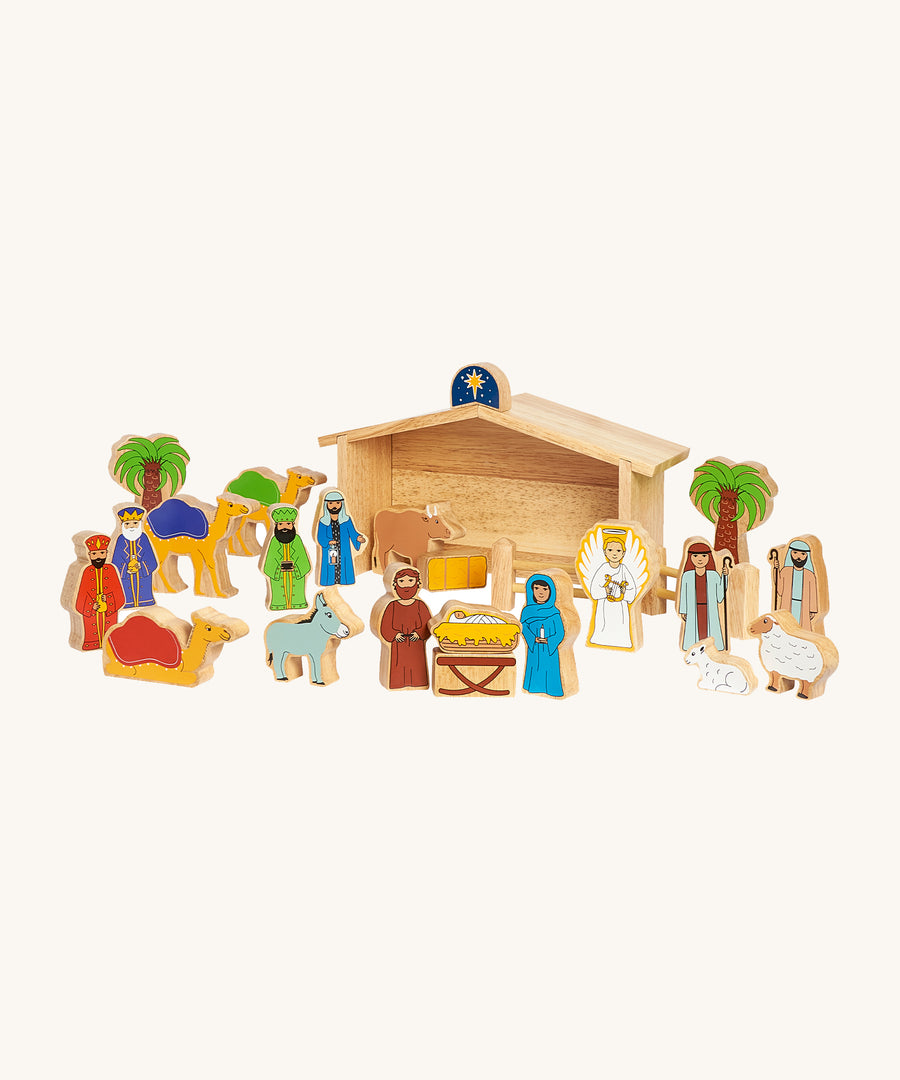 Lanka Kade Deluxe Nativity Set with wooden animal and people figures, and a wooden barn on a cream background. The figures include Mary, Joseph, Baby in a Manger, an Angel, the Three Kings, Shepard's, Sheep, Camels, Trees, a Donkey, a Bull and the Northern Star on a cream background 