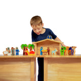 A child playing with the Lanka Kade Deluxe Nativity Set toy on a wooden table