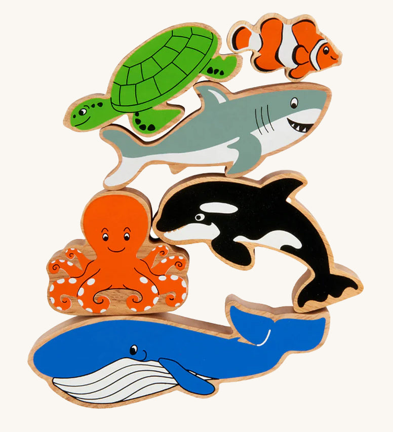 Lanka Kade Wooden Sealife Animals Bag of 6, are fun marine life figures and include a whale, an octopus, an orca, a shark, a turtle and a clown fish, all with happy and smiling faces. The image is on a cream background