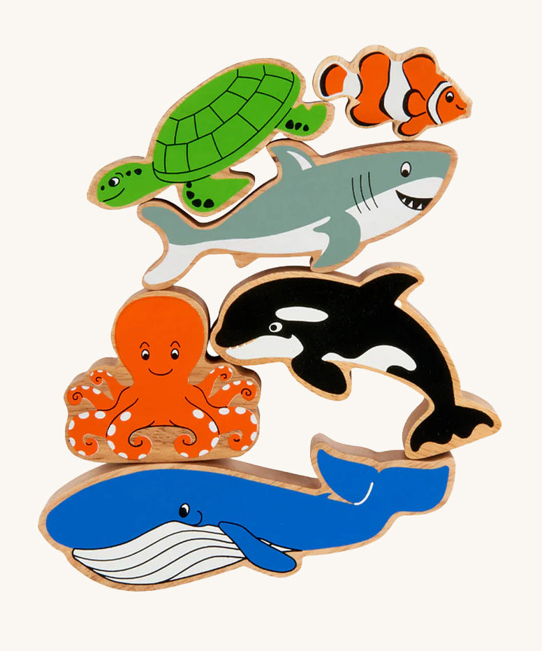 Lanka Kade Wooden Sealife Animals Bag of 6, are fun marine life figures and include a whale, an octopus, an orca, a shark, a turtle and a clown fish, all with happy and smiling faces. The image is on a cream background