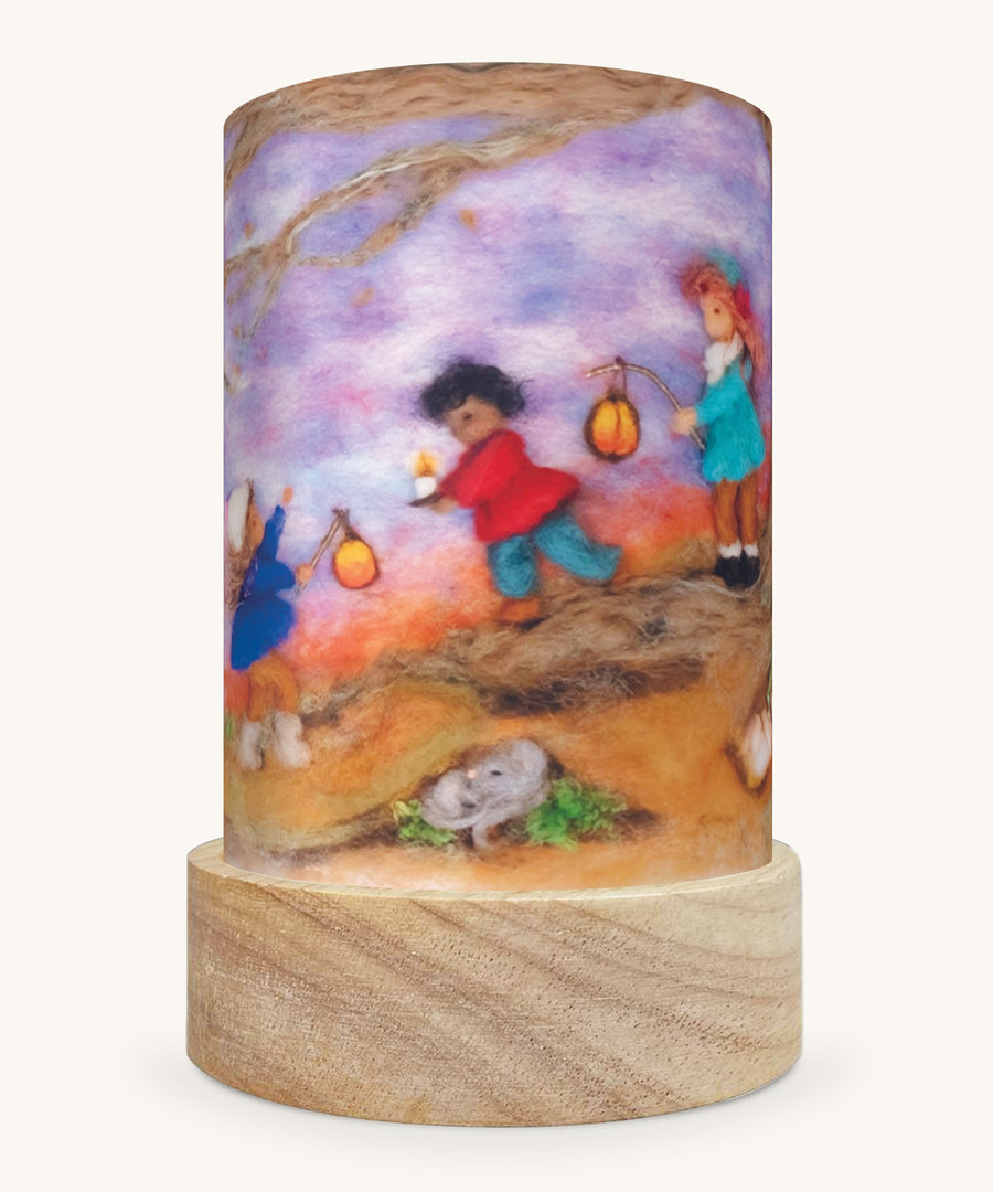 The Lantern Walk illustration by Het Wol Feetje sat in a Toverlux Magic Lantern base, on a cream background