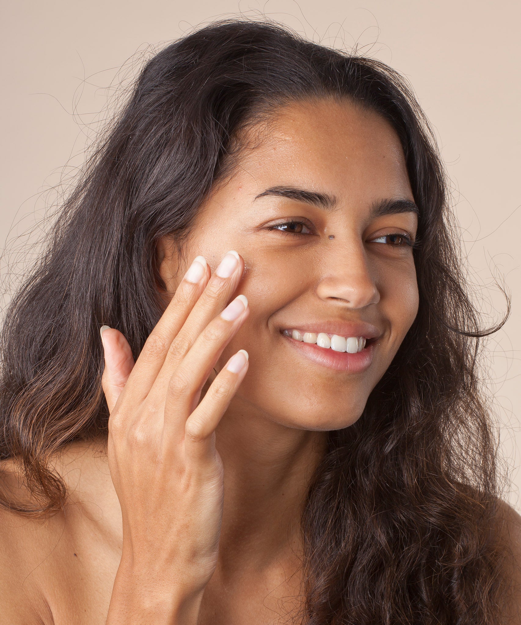 A person rubbing in the Green People Nordic Roots Hyaluronic Booster Serum, in to their skin. The serum is sheer and non greasy in texture