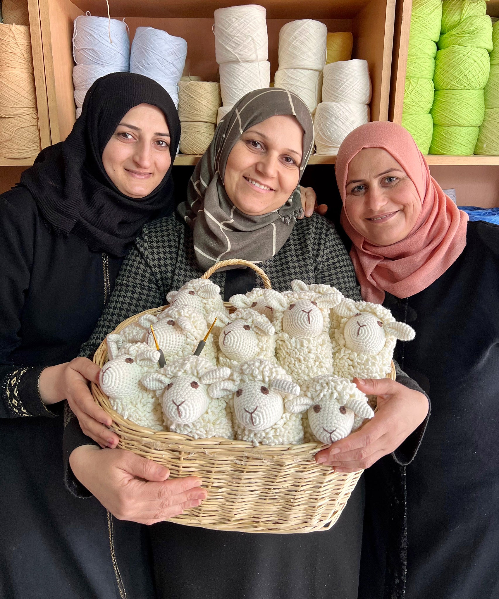 Bebemoss crochet artisans holding a basket of handmade, crochet sheep