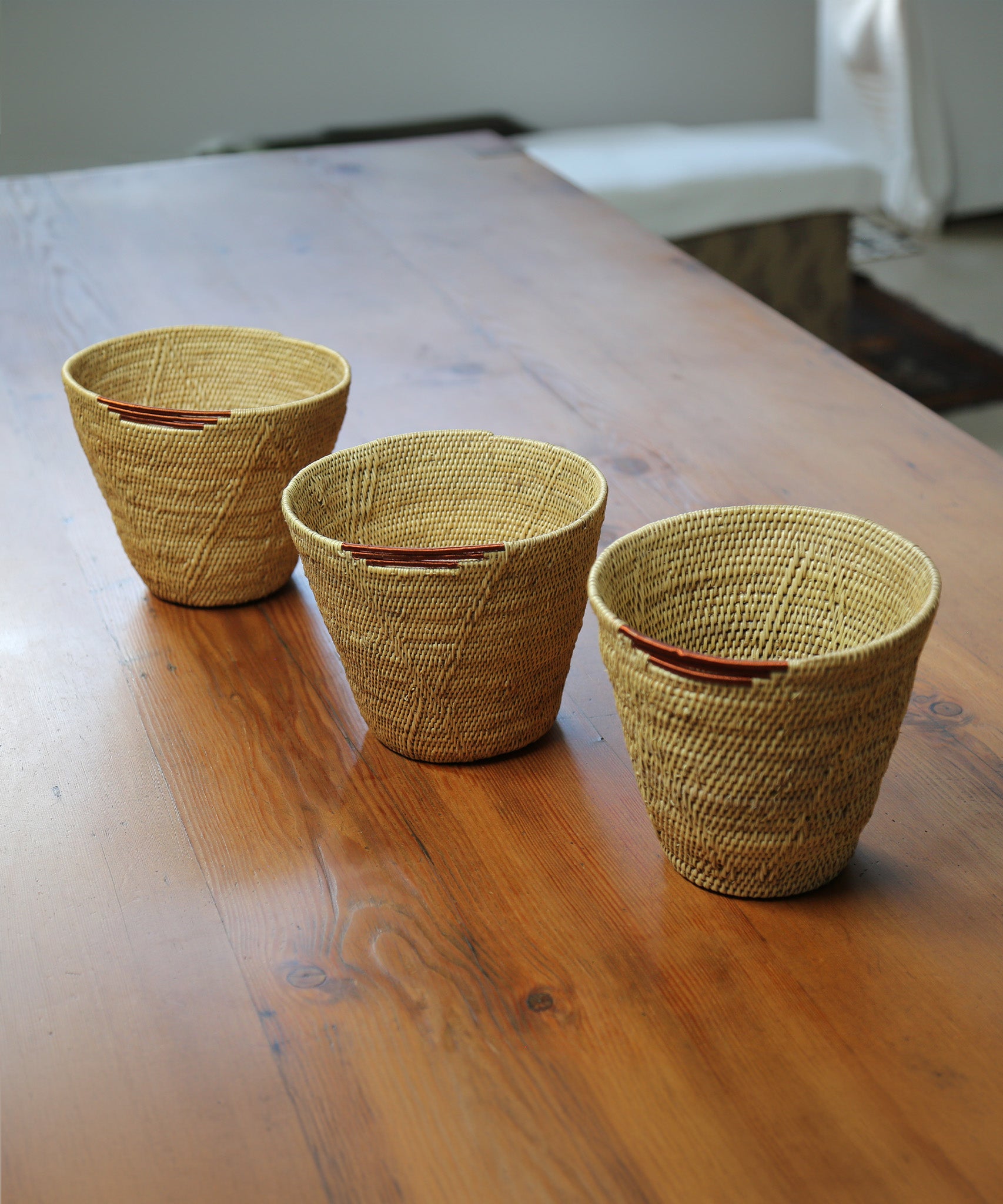 3 MADE51 Small Handmade Makenge Basket on a wooden table, stood in a row