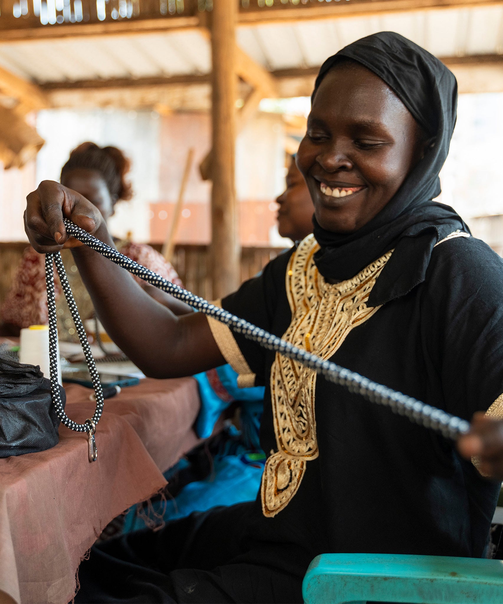 A bead crafting artisan refugee creating a beautiful bead necklace