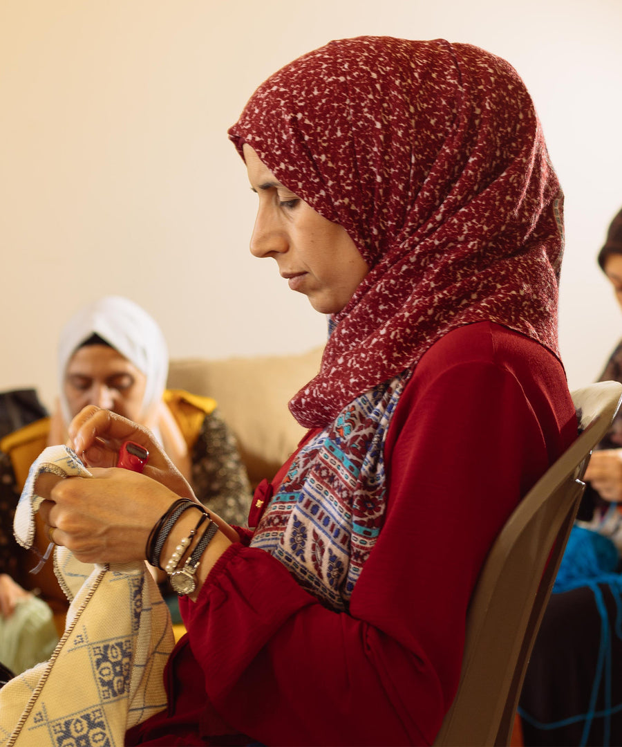 A Syrian refugee creating a beautiful blanket made in partnership with Oshana and MADE51