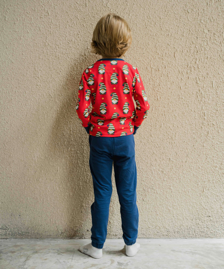 A child wearing a Maxomorra Swedish Santa Long Sleeve top, facing away from the camera showing the back of the top. The child is stood in front of a beige coloured wall.