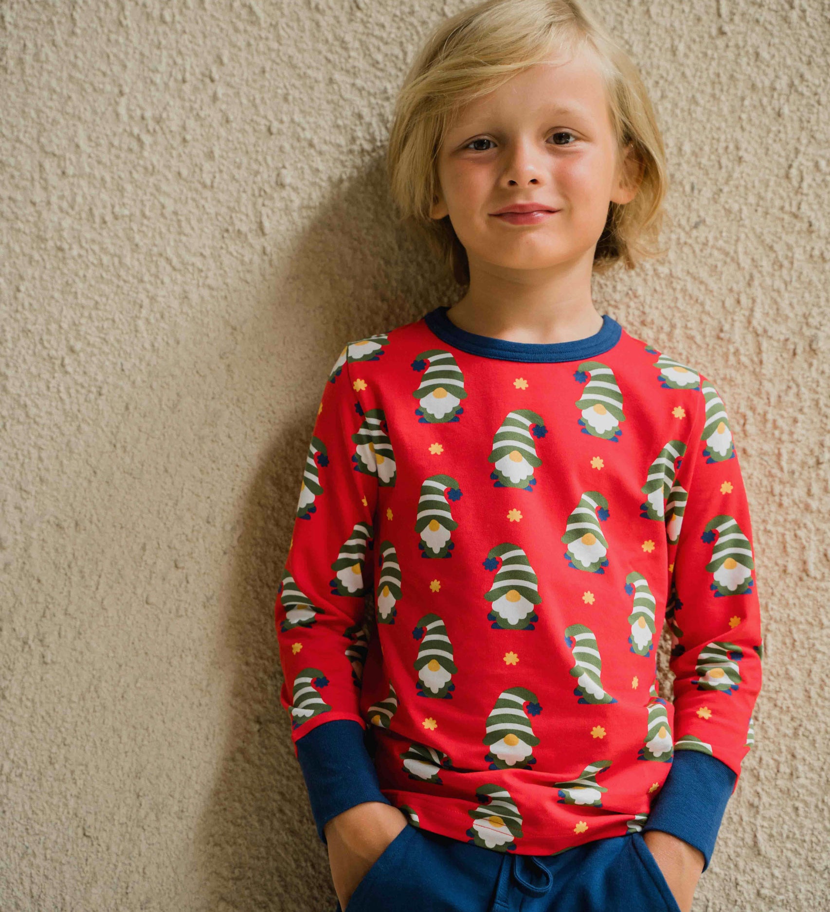 A child wearing a Maxomorra Swedish Santa Long Sleeve top. The child is stood in front of a beige coloured wall.