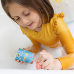 A girl drawing in the bath tub with the Medenka beeswax bath crayons. 