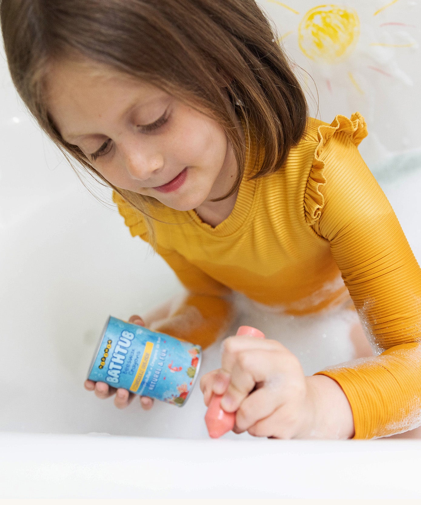 A girl drawing in the bath tub with the Medenka beeswax bath crayons. 