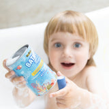 A child happily holding up a pack of Medenka beeswax bath crayons in the bath.