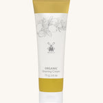 MÜHLE Organic Shaving Cream in a mustard and white tube with delicate olive branch design on the packaging and the Muhle logo in the middle. On a cream background