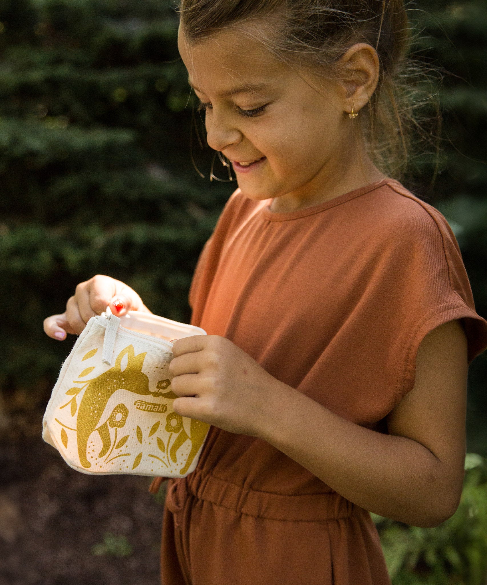 A child looking into the Namaki Gold Fox Sparkling Pouch