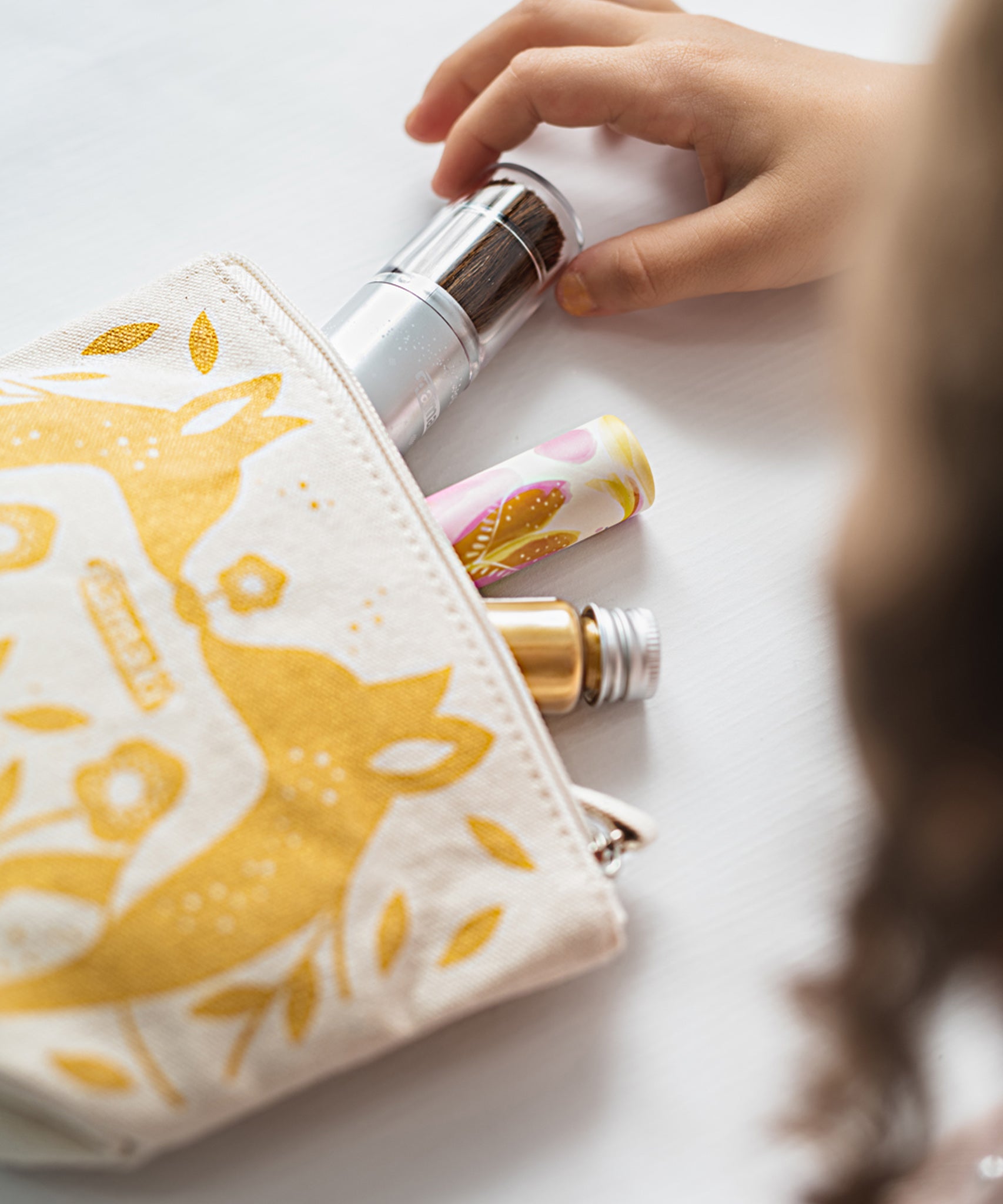 A child taking out the make up from the Namaki Gold Fox Sparkling Pouch