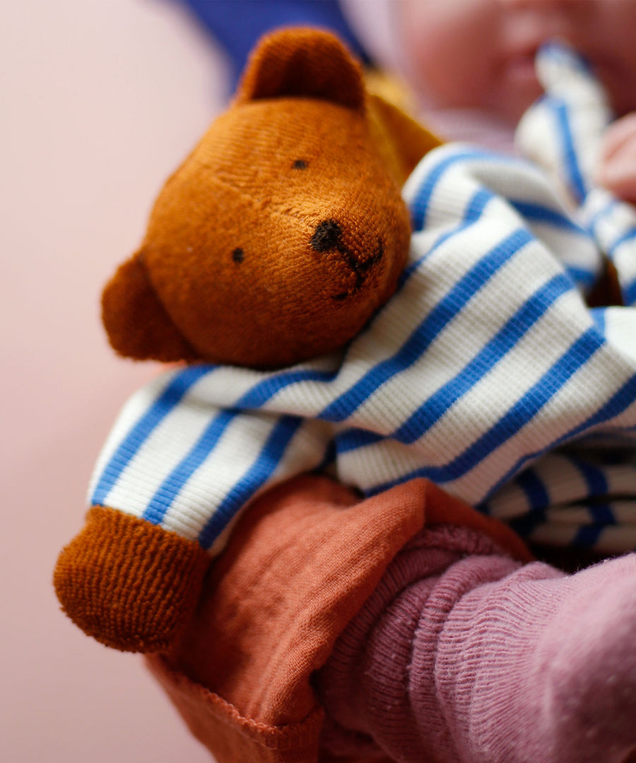 A beautifully handmade teddy bear comforter toy, the Nanchen Baby Comforter - Bear has brown face and  hands, and a blue and white stripe body