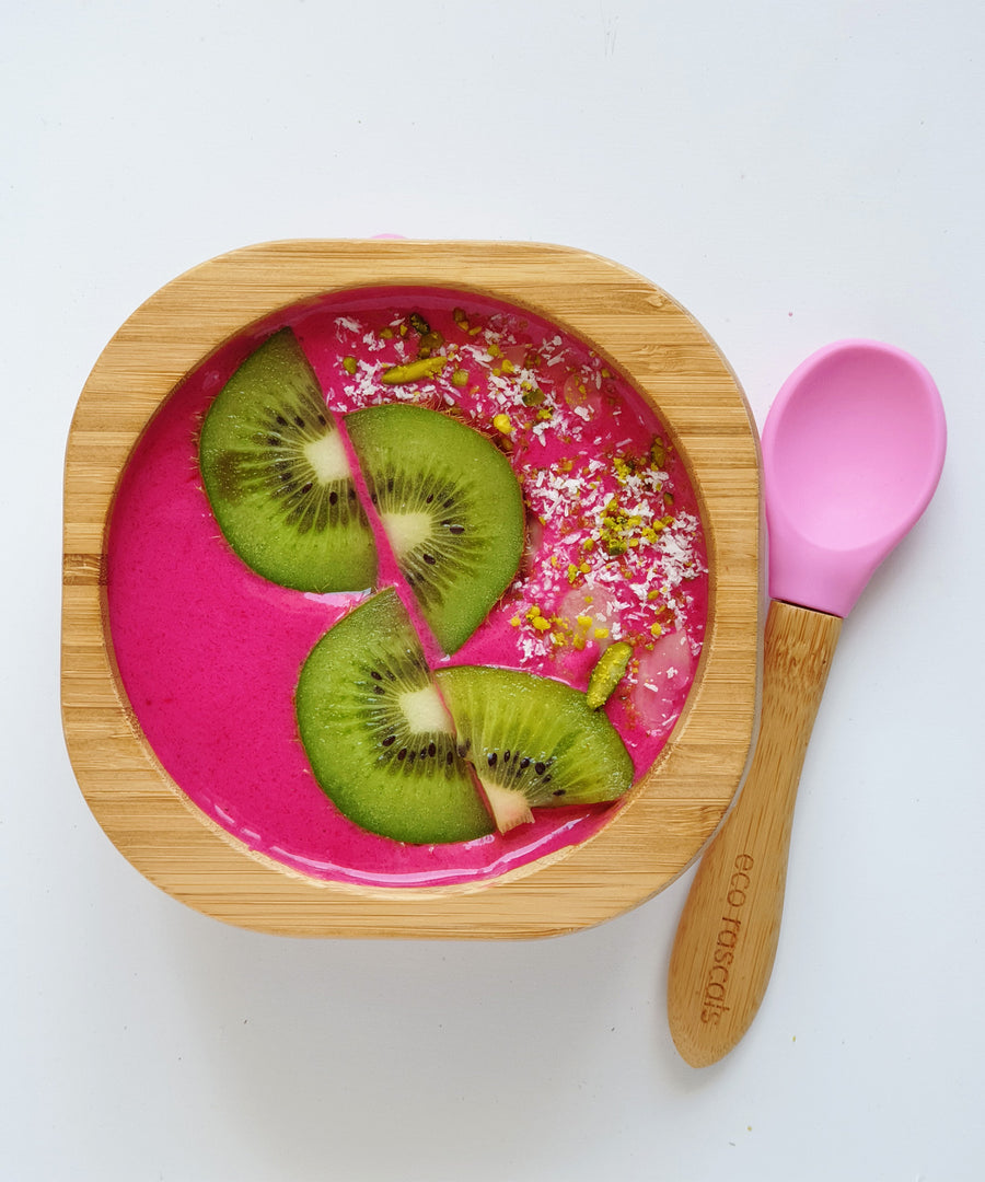 A pink desert with fresh kiwi fruit in the Eco Rascals Bamboo Bowl & Spoon Weaning Set in pink silicone.