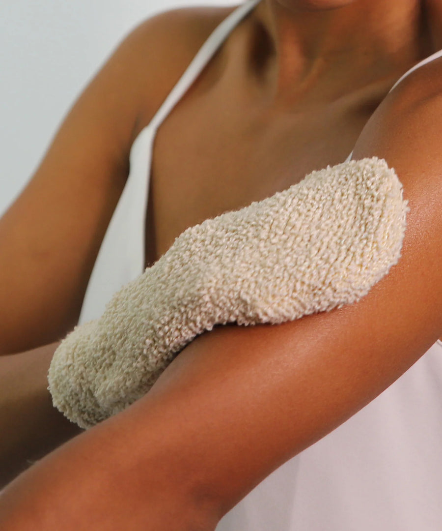 A person using the Green People Exfoliating Mitt on their arm