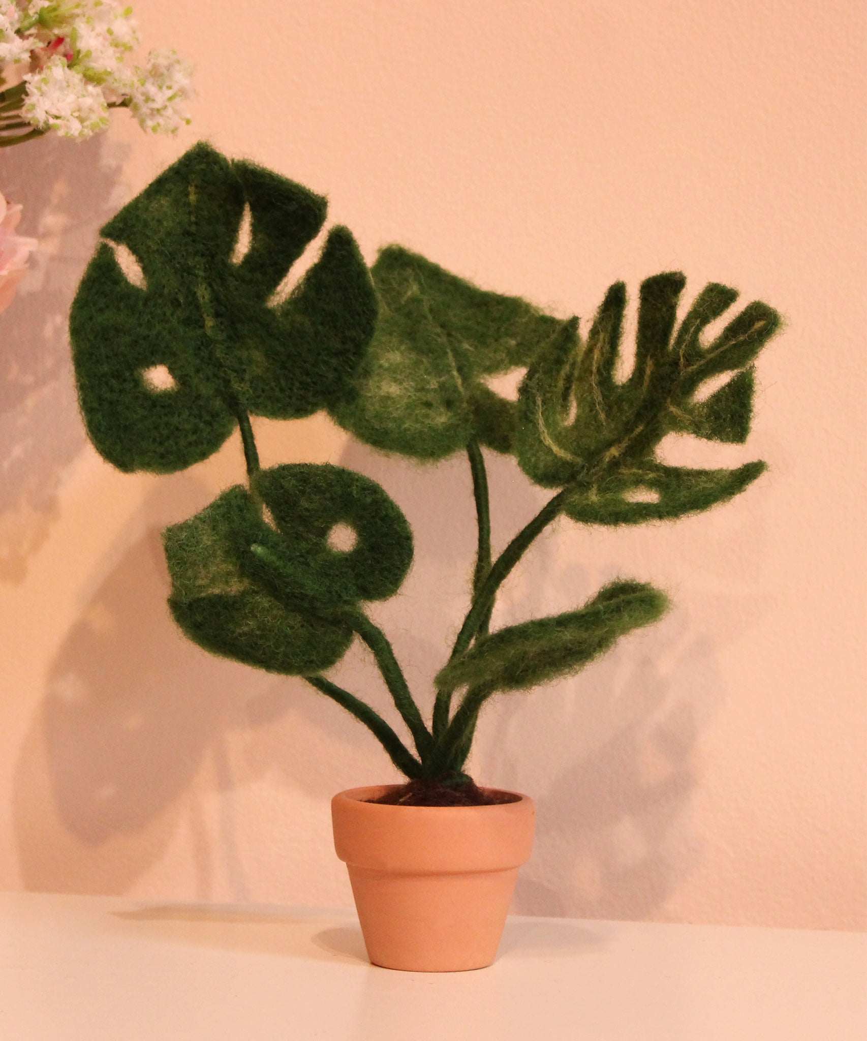 The Makerss - Monstera Plant Small Needle Felt Kit in a small ceramic pot on a pink background