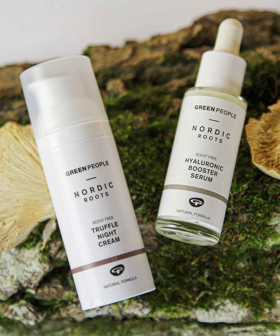 The scent free, soothing and organic Nordic Roots Truffle Night Cream and Hyaluronic Booster Serum laid out on a mossy background with chanterelle mushrooms