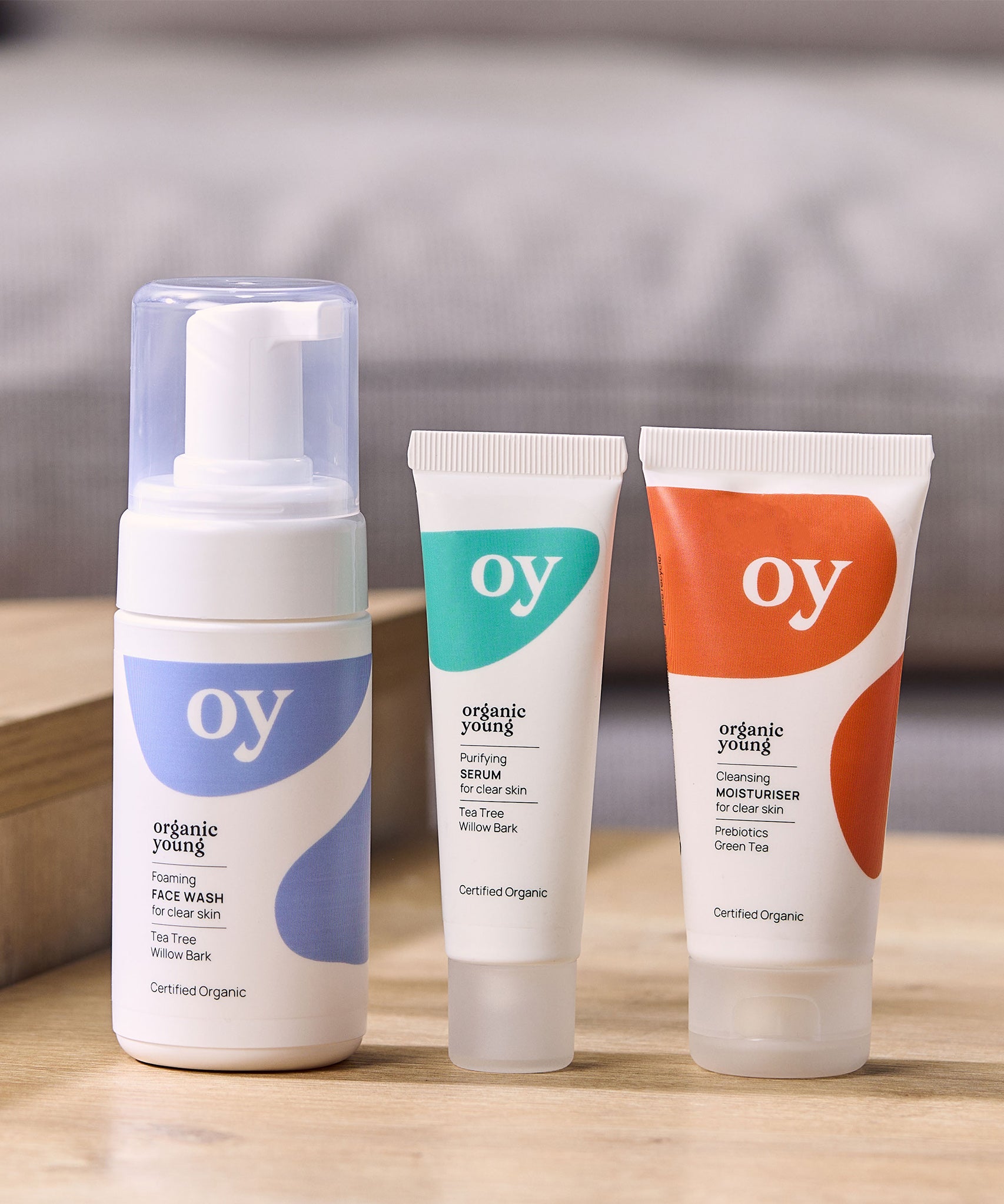 The Green People OY Skincare set of face wash, serum and moisturiser, set on a wooden table