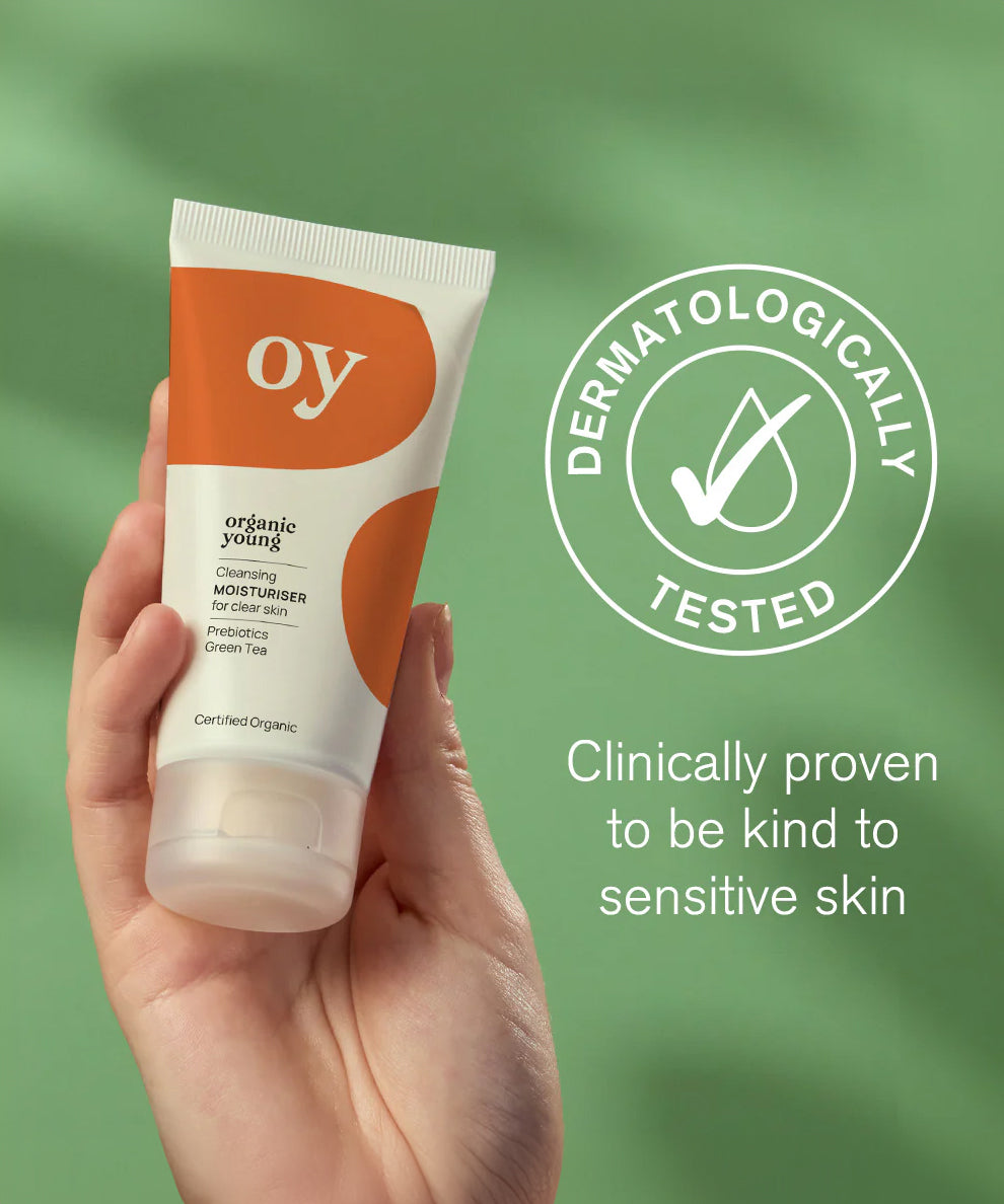 The OY! Clear Skin Cleansing Moisturiser pictured in a persons hand with a Dermatologically tested logo