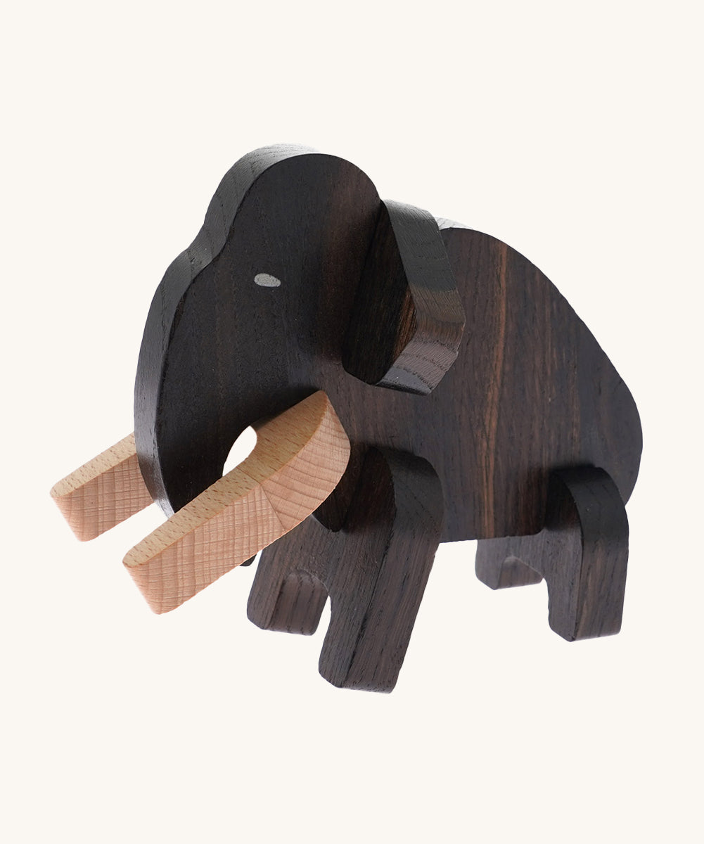 The Bajo Puzzle & Sorter - Black Oak Mammoth which has been made. The mammoth has light coloured wooden tusks and a dark wooden body. On a cream background