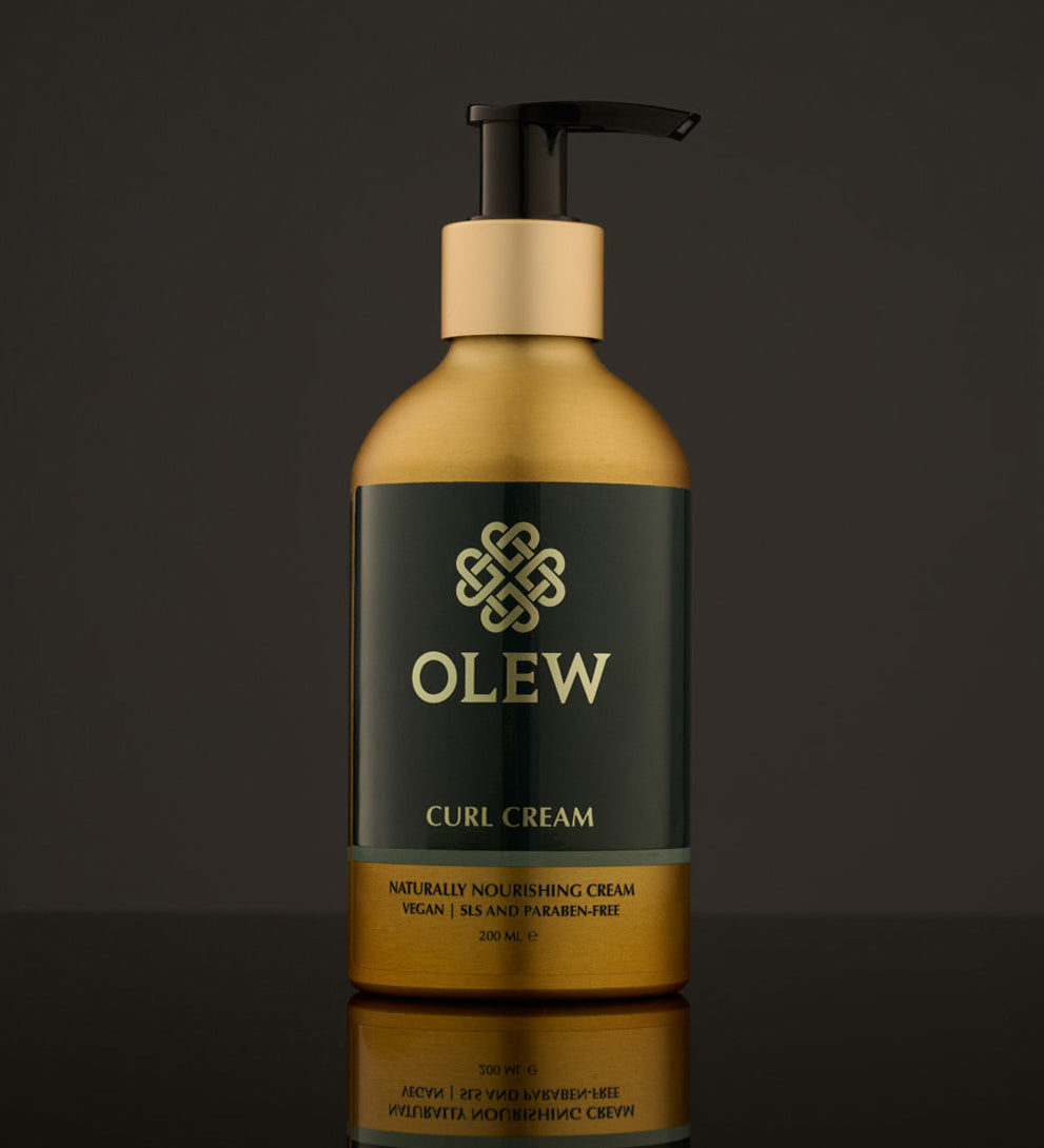 Olew Naturally Nourishing Curl Defining Cream, vegan haircare which is SLS and Paraben Free in a gold and dark green bottle with an push down pump top, on a dark grey background