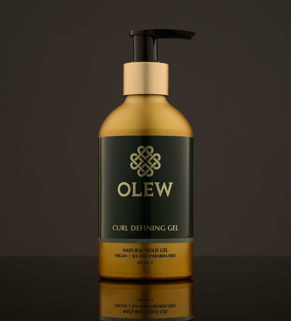 Olew Curl Defining Natural Hold Gel, vegan haircare which is SLS and Paraben Free in a gold and dark green bottle with a push down pump top, on a dark grey background