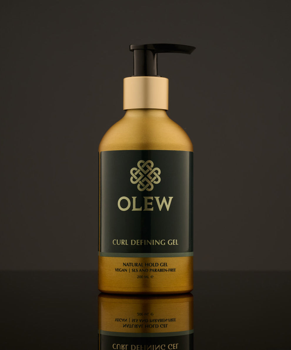 Olew Curl Defining Natural Hold Gel, vegan haircare which is SLS and Paraben Free in a gold and dark green bottle with a push down pump top, on a dark grey background