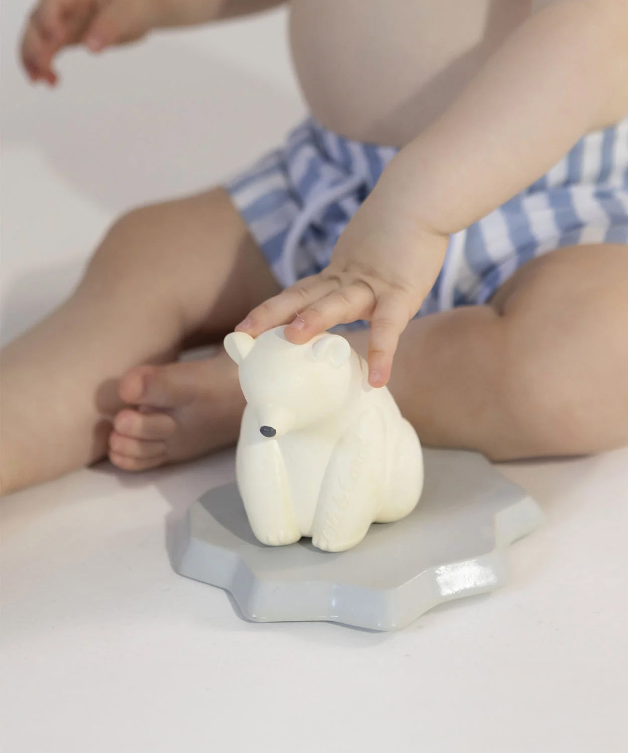 A child playing with the Oli & Carol Polar Bear Bath Toy Set with the Polar Bear stood on its floating base