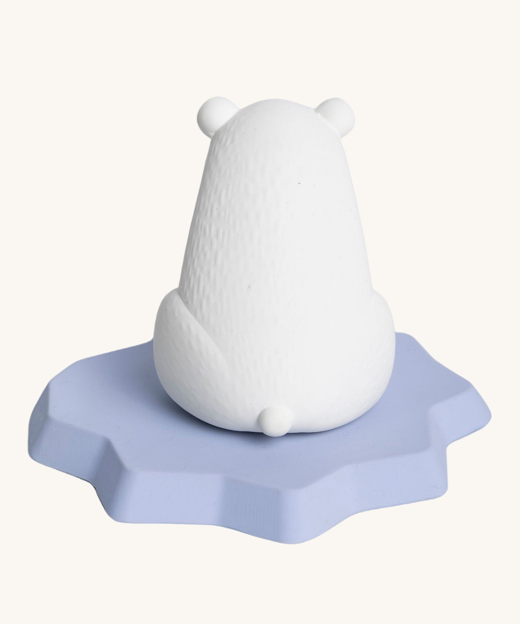 The back of the Oli & Carol Polar Bear Bath Toy showing a little polar bear tail and the texture of the natural rubber. On a cream background