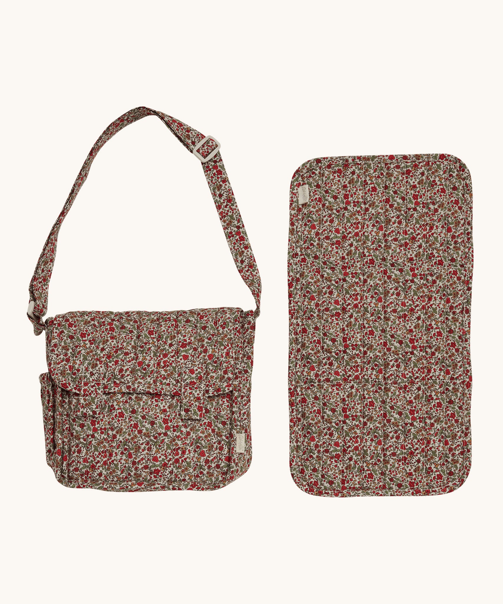 The Olli Ella Carrie Convertible Changing Set in Garland. The image shows the changing bag and the converted changing mat side by side, on a cream background.