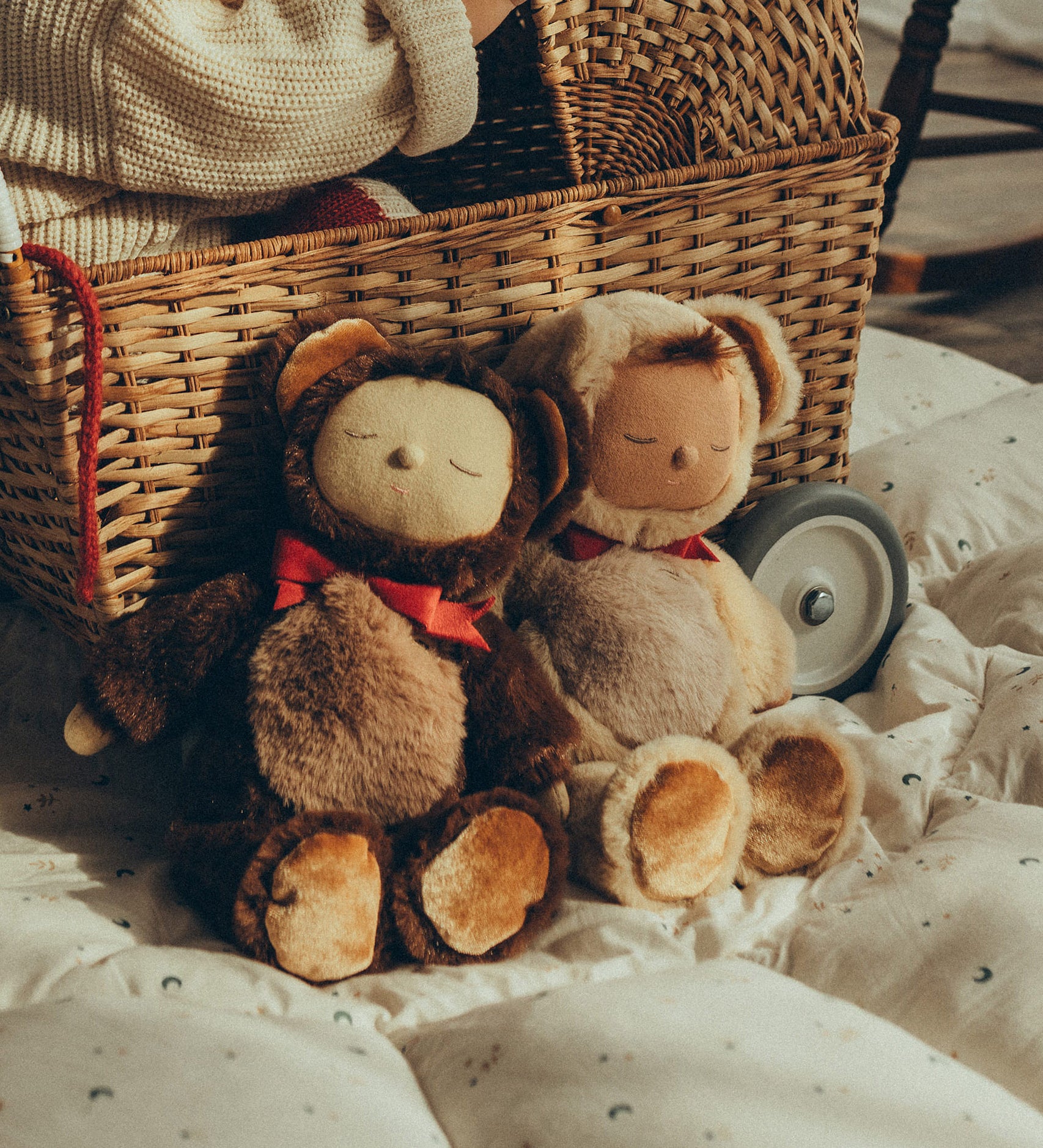 Olli Ella Cozy Dinkum Dolls Teddy Twiggy and Teddy Crumble together , sat in front of an Olli Ella Strolley Pram with a child sat inside.