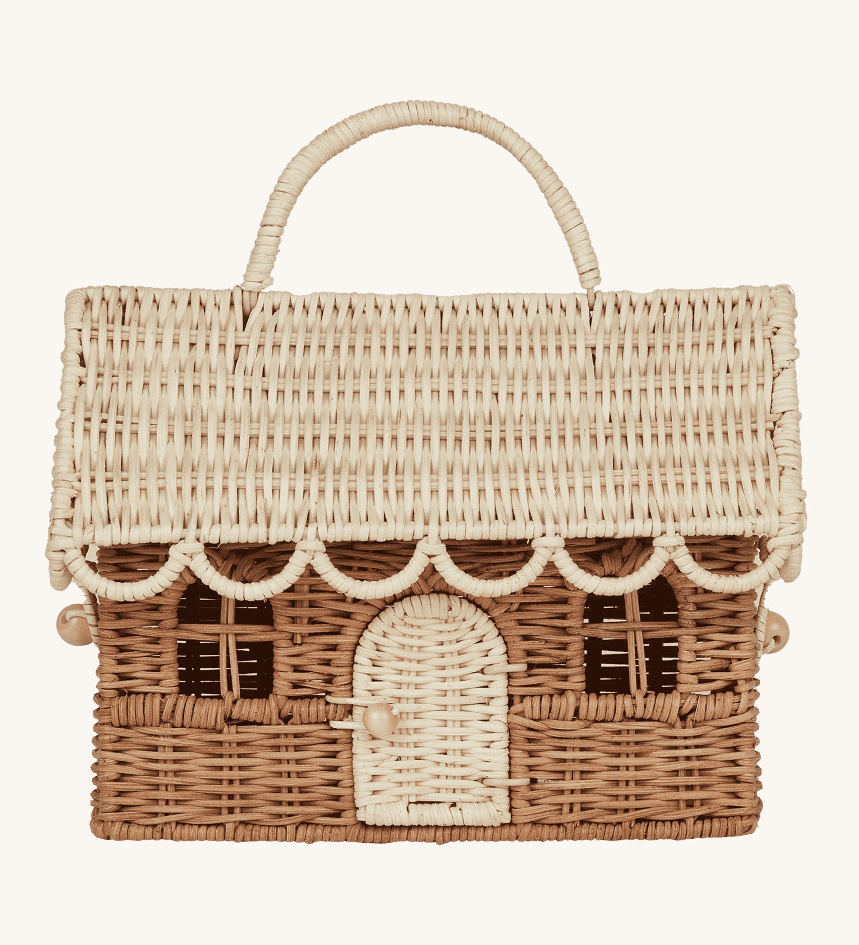 The Olli Ella Rattan Gingerbread House Basket - Natural & Straw, is a handwoven basket made to look like a festive gingerbread house. The lid is removable and the door on the font can open and close. The lid and door are a light cream colour and the main body of the basket is a darker brown colour. The image is on a cream background